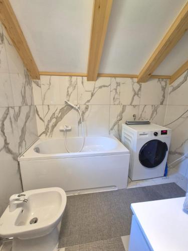 a bathroom with a tub and a toilet and a sink at Villa DORA in Vrbovsko