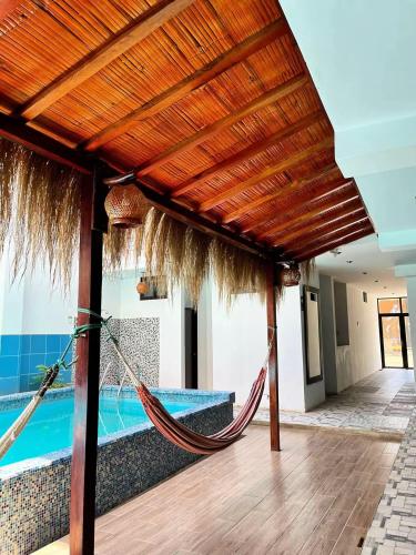 a hammock in a villa with a swimming pool at Hospedaje Dora in Máncora