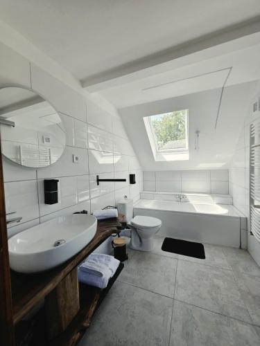 a bathroom with a tub and a sink and a toilet at Komondor Vendégház in Vácrátót
