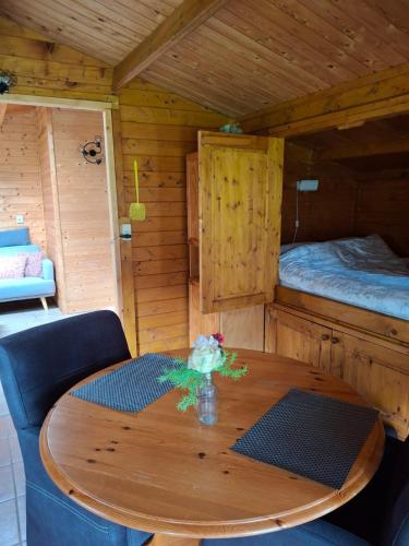a wooden room with a wooden table and a bed at Blokhut Bron van Rust in Opende