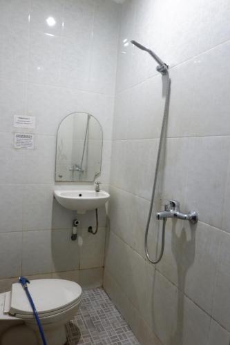 a bathroom with a shower and a toilet and a sink at Hy ReDz in Palopo