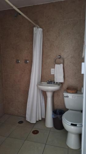 a bathroom with a toilet and a white shower curtain at Los Pueblitos de Guanajuato in Guanajuato