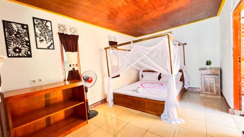 a bedroom with a bed with a mosquito net at Sunset Cottages in Hitokalak