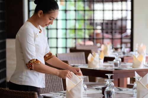 a woman standing in a restaurant preparing food at Grand Luley Manado in Manado