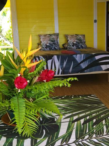 a porch with two beds with flowers on it at Hitirā Lodge presqu'île in Atihiva
