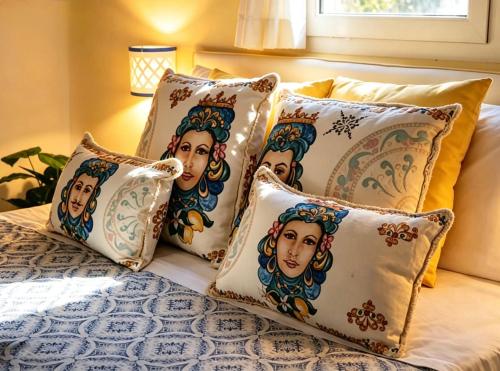 a group of four pillows on a bed at Maison La Torretta in Vico Equense