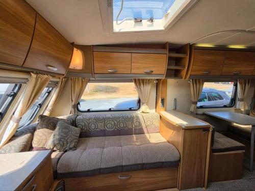 an interior of an rv with a bed and a window at La Rulote in Căpăţîneni-Ungureni