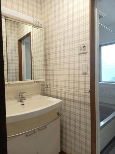 a bathroom with a sink and a mirror at 一棟貸切民宿Saisai 3部屋 in Sakai