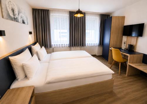 a hotel room with a large bed and a desk at Hotel Central Nürnberg Hauptbahnhof in Nuremberg