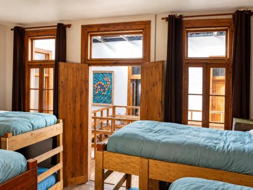 a room with three bunk beds and windows at Hostal Licanantay in Valparaíso