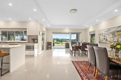 a kitchen and dining room with a table and chairs at Mole Hill Farmhouse in Lovedale