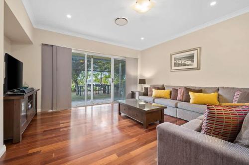 a living room with a couch and a tv at Mole Hill Farmhouse in Lovedale
