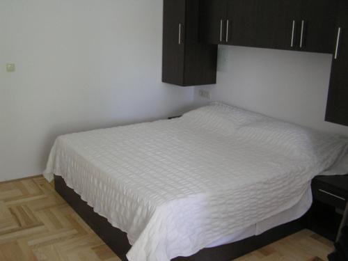 a bedroom with a white bed with black cabinets at Apartments Despot Zaostrog RY in Zaostrog