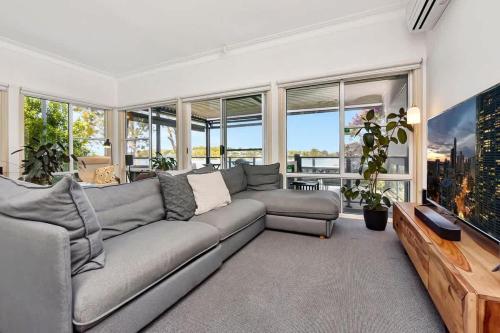 a living room with a large couch and windows at Lakehouse on Alexander in Arcadia