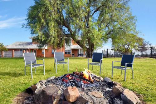 a group of chairs around a fire pit at Beggars Bridge Vineyard Homestead with pool and tennis in Rothbury
