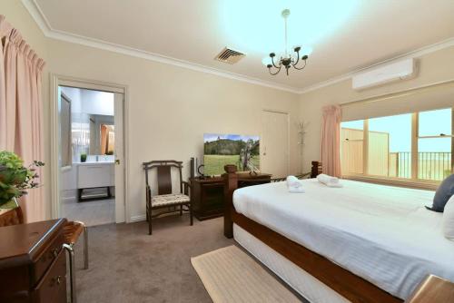a bedroom with a bed and a desk and a window at King 2 - close proximity to Bimbadgen and Hope Estate concerts in Pokolbin