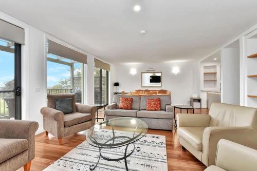a living room with couches and a glass table at Villa 3br Malbec Villa located within Cypress Lakes Resort in Pokolbin