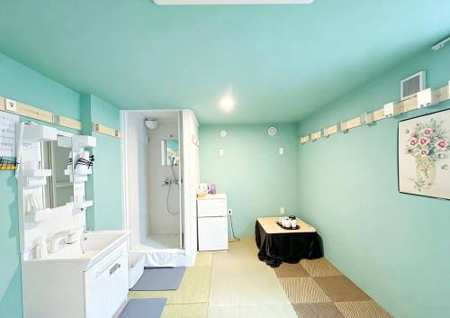 a bathroom with blue walls and a sink and a table at Hananosato 池袋本店 池袋駅から近く 新宿渋谷銀座へ移動しやすい 周辺に 24 時間コンビニ 昔ながらの銭湯があり 人気の漫画本店も徒歩圏内 多様なタイプの客室を取り揃え 東京観光 都市散策 ショッピングにおすすめ in Tokyo