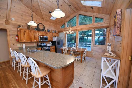 a kitchen and dining room with a large island in a cabin at 6BR/5BA Retreat • Hot Tub • Game Room • Treehouse in Blue Ridge