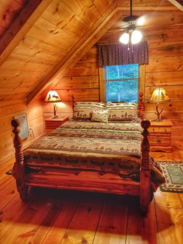 a bedroom with a bed in a log cabin at Trail`s End-Hot tub-wifi,-pets ok-Pool Table-Fireplace-Screened Porch-Activities in Mashburn Mill