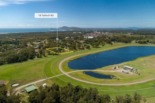 an aerial view of a golf course with a lake at Tulloch Estate in Tuncurry