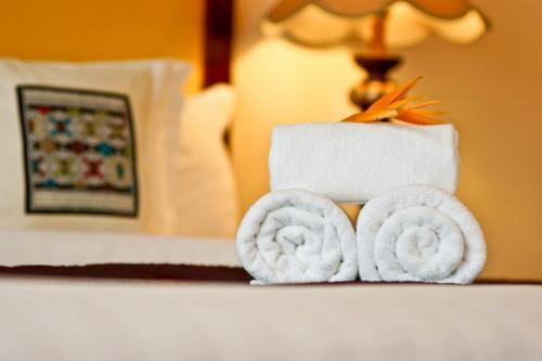 una pila de toallas en una mesa en una habitación de hotel en Champasak Grand Hotel, en Pakse