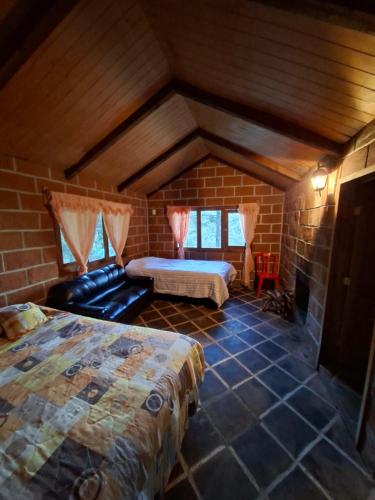 a bedroom with two beds and a couch in a room at Rancho buena vista in Mineral del Chico