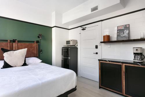 a bedroom with a white bed and a refrigerator at 1BR Escape Queen Bed WiFi & Kitchenette in San Diego