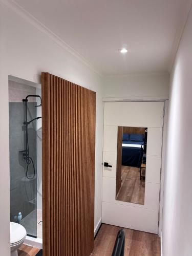 a bathroom with a wooden partition and a toilet at The Almas Container in Willemstad