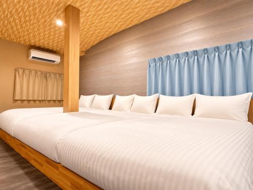 a bedroom with a large bed with white pillows at WholeHouse Himeji Castle ホールハウス 姫路 in Himeji