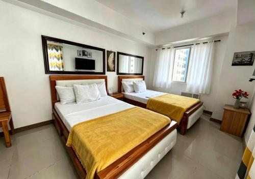 a hotel room with two beds and a television at Sea Residences Sunset Point in Manila