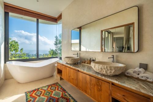 a bathroom with two sinks and a large mirror at Villa Karilla in Toyapakeh