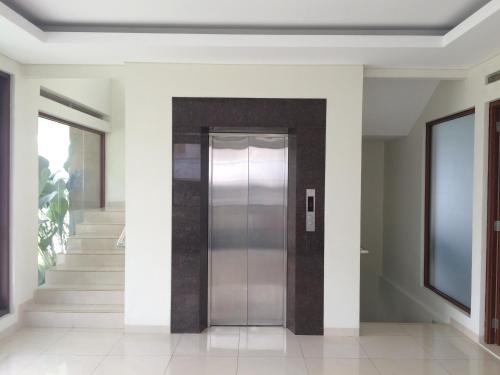 a hallway with a metal elevator in a house at Roemah Asri Villa - Resor Dago Pakar in Bandung