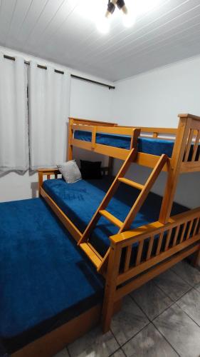 a bedroom with two bunk beds with blue sheets at Propriedade Mendes&Souza - Pinhais in Pinhais