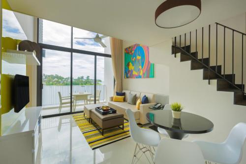 a living room filled with furniture and a large window at Cassia Phuket - SHA Extra Plus in Bang Tao Beach