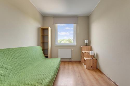 a bedroom with a green bed and a window at Słoneczny Widok in Gdynia