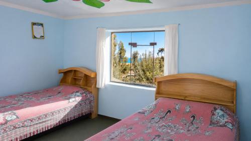 a bedroom with a bed and a window at Dawn House - Lago Titicaca in Ocosuyo
