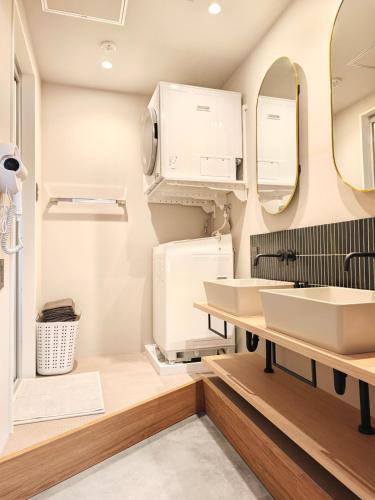 a bathroom with two sinks and a mirror at Hotel Matoma 別館 in Tokyo
