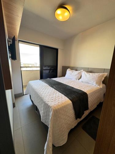 a bedroom with a large bed with a large window at Studio próximo a UFU Sta Monica e Center shopping in Uberlândia
