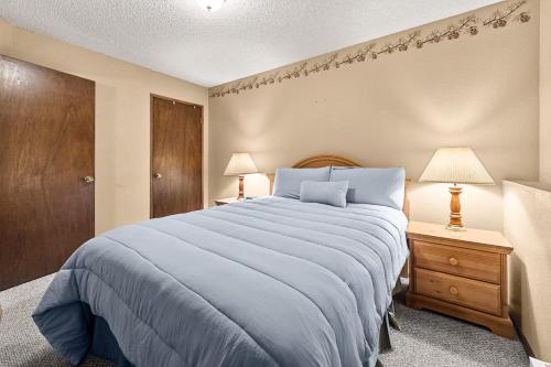 a bedroom with a large bed and two lamps at Limber Pine Townhome and 2BDR Stay in Whitefish