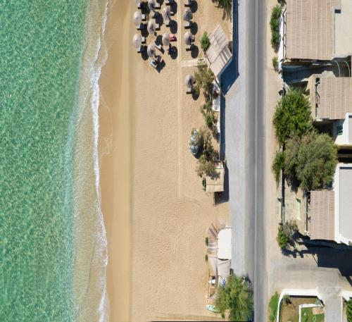 vue aérienne d'une plage avec des parasols et l'océan dans l'établissement Beachfront Pleasure, à Kypri
