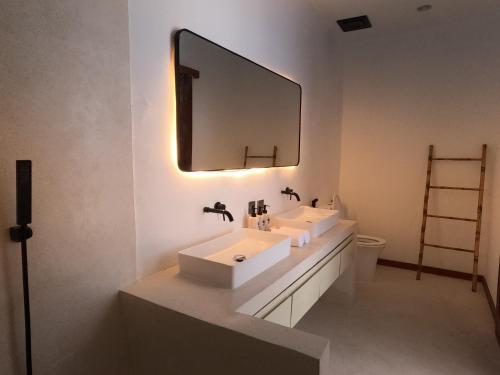 a bathroom with two sinks and a large mirror at The Siren Resort Nusa Penida - Ocean View Villas in Nusa Penida
