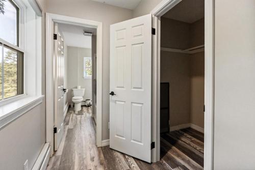 a bathroom with a white door and a toilet at Spacious Colonial Large Groups Fire Pit in Brewer