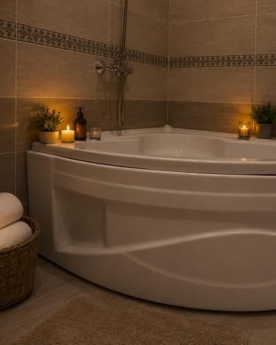 a white bath tub in a bathroom with candles at Green City Hotel ШАХРИСАБЗ in Khujand
