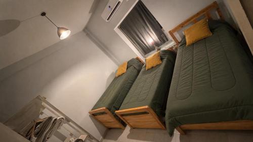 a large green bed in a small room at Monica’s Apartments in Canning
