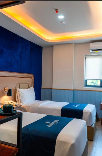 a hotel room with two beds and a table at du PALAIS Hotel in Sultan Thaha Airport