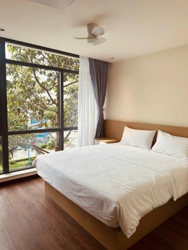 a bedroom with a large bed and a large window at The Cloud Hotel Bình Dương in Ga Phú Trung