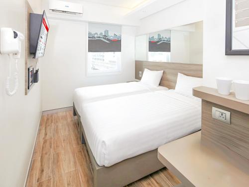 a bedroom with a large white bed and a desk at Red Planet Manila Binondo in Manila