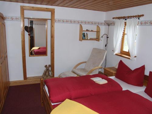 1 dormitorio con cama, silla y espejo en Ferienwohnung Hockert, en Waltersdorf