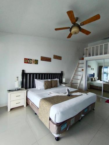 a bedroom with a large bed with a ceiling fan at the beachhouse cebu in Dalaguete